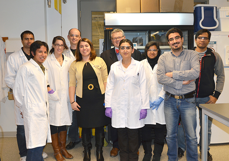 Randall Findlay (background) poses with Assoc. Prof. Cigdem Eskicioglu (yellow sweater) and students who work in the UBC Bioreactor Technology Group. Photo credit: Patty Wellborn